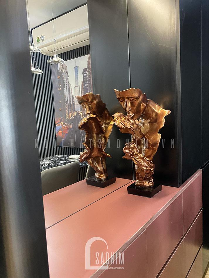 Hệ tủ đa năng điểm nhấn đến từ ngăn tủ màu đỏ mận và đèn led, tượng tình yêu vĩnh cửu đặt trang trí tại đây