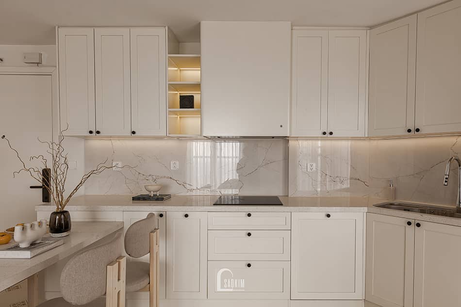 Thiết kế thi công nội thất phòng bếp chung cư Aqua Bay Ecopark với phong cách Parisian lựa chọn tủ bếp cánh phẳng kết hợp phào chỉ nhẹ.